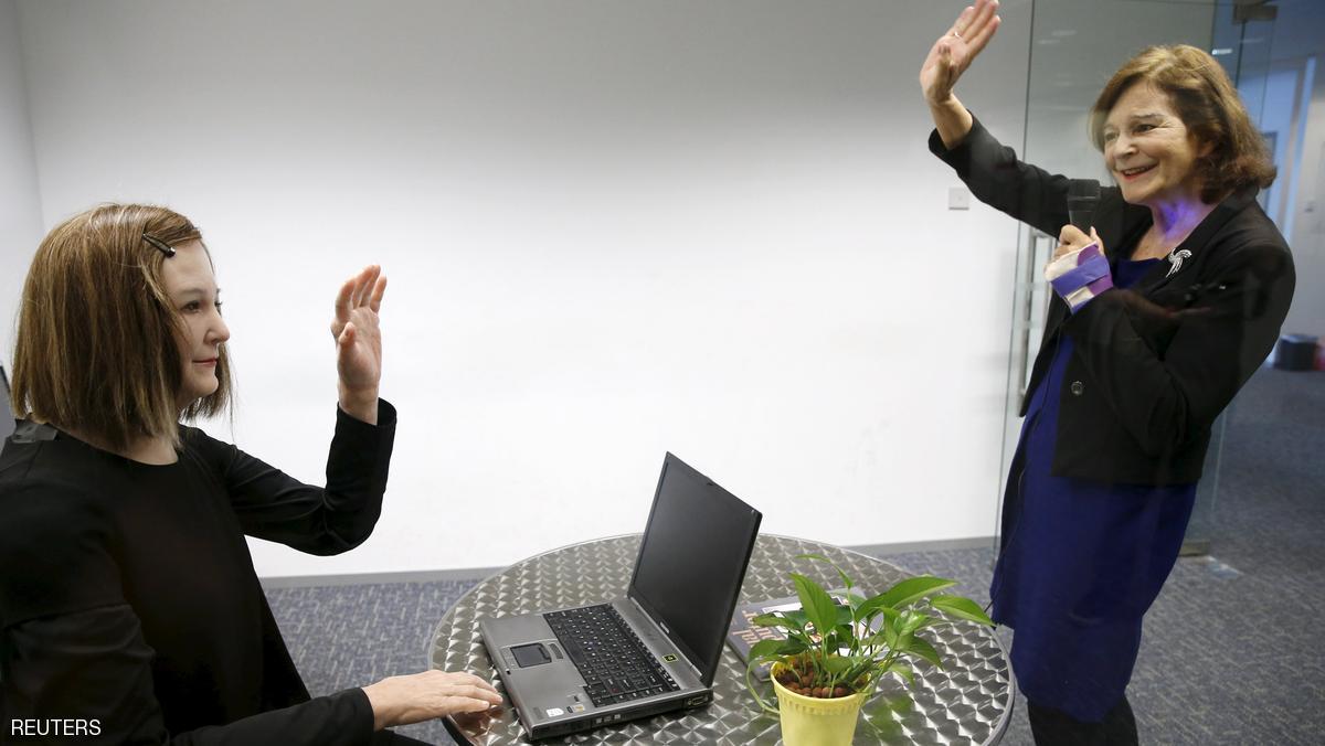 Nanyang Technological University's (NTU) Professor Nadia Thalmann (R) talks to Nadine, a humanoid that she and her team created, during an interview with Reuters at their campus in Singapore March 1, 2016. With her brown hair, soft skin and expressive face, Nadine is a new brand of human-like robot that could one day, scientists hope, be used as a personal assistant or care provider for the elderly. Picture taken March 1.  REUTERS/Edgar Su